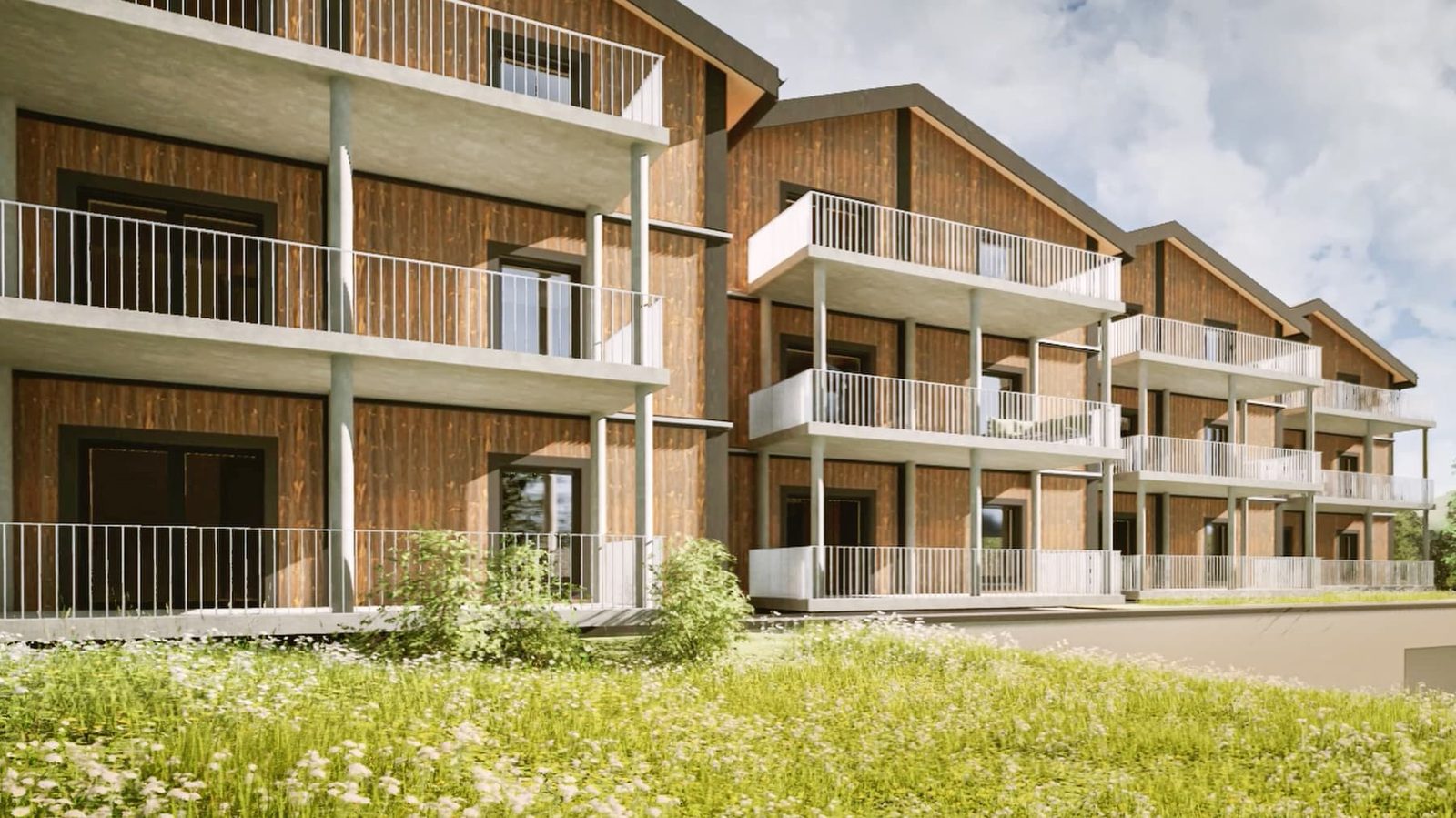 Mondhaus Resort Fiesch: Balkone der Mehrfamilienhäuser über der Blumenwiese