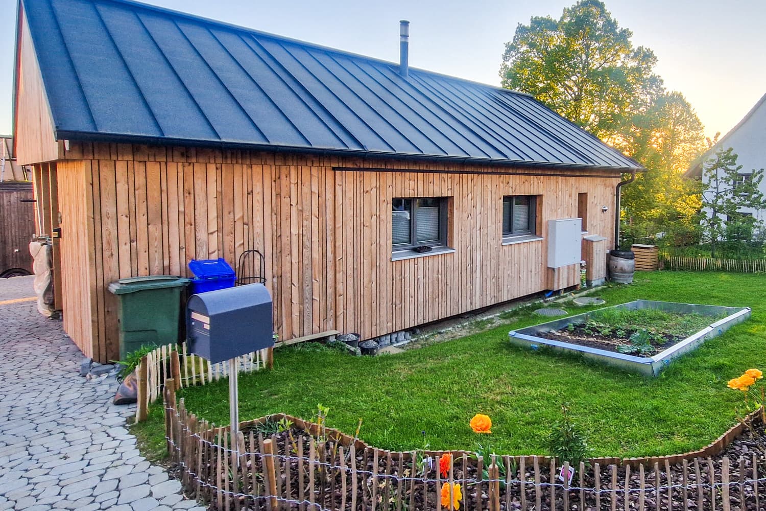 ZINIPI 3-ModulHaus in Gallenkirch AG: Längsseite mit Garten und Metalldach