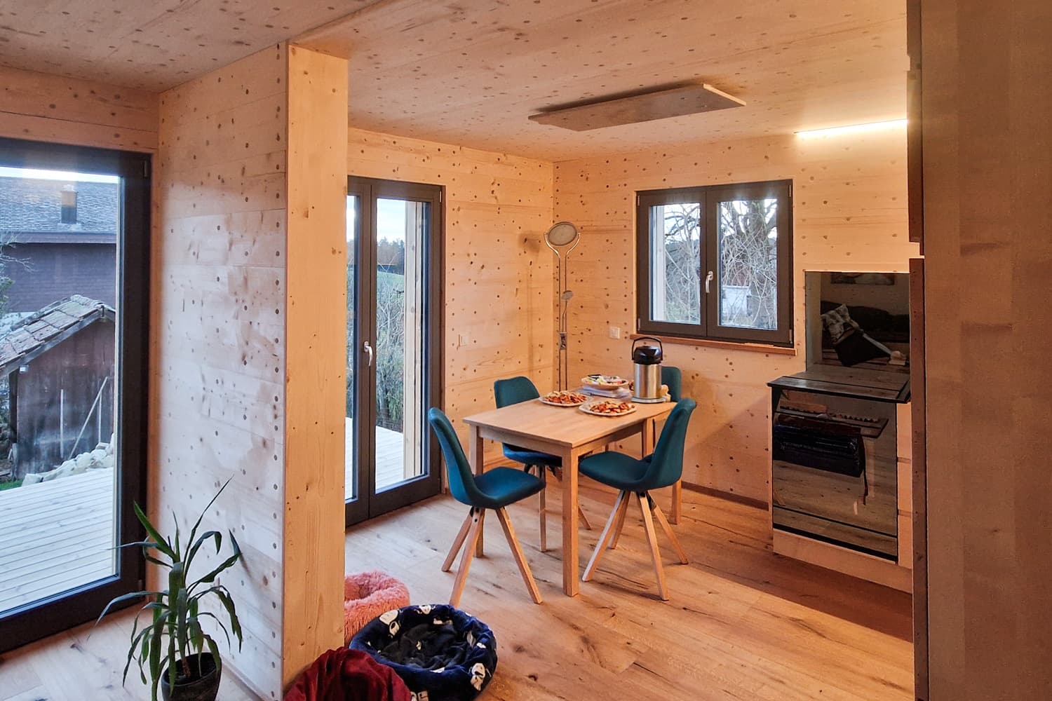 ZINIPI 3-ModulHaus in Gallenkirch AG: Wohnküche mit Esstisch und Fenstertür zur Terrasse